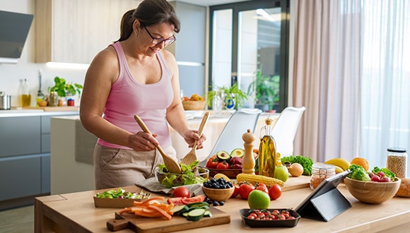 Woman in the kitchen cooking with healthy ingredients