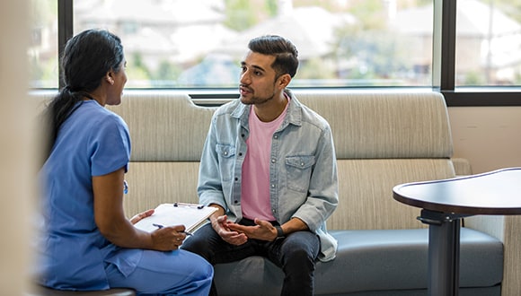 Man speaking with a nurse about his hospital excess