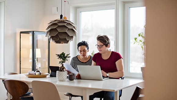 Couple researching home and contents insurance on a laptop