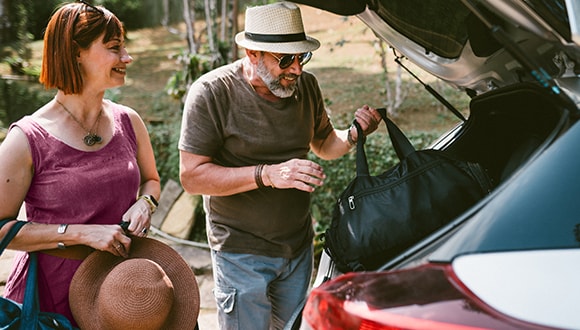 Man and woman unloading a car boot