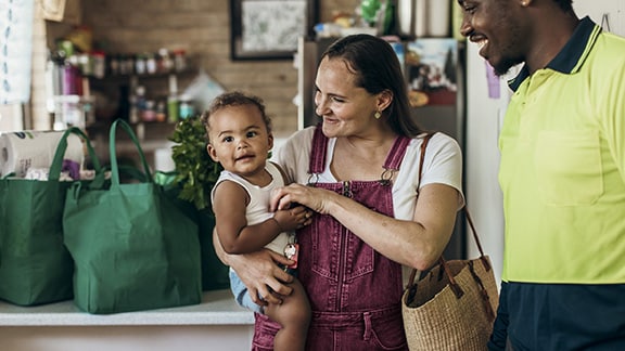 A mother holding a baby next to a tradesman at a café